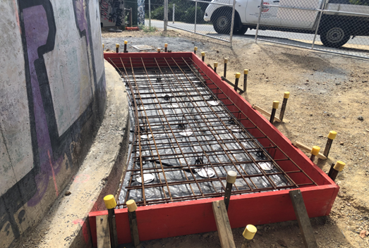 A construction site with a red frame and metal rods

Description automatically generated