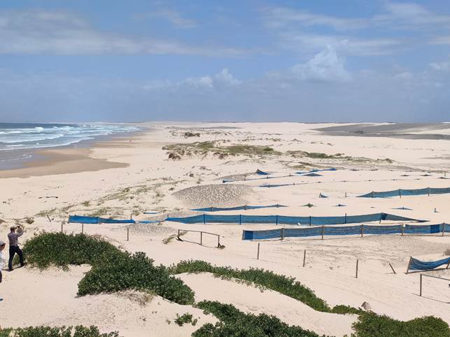 A sandy beach with blue nets

Description automatically generated