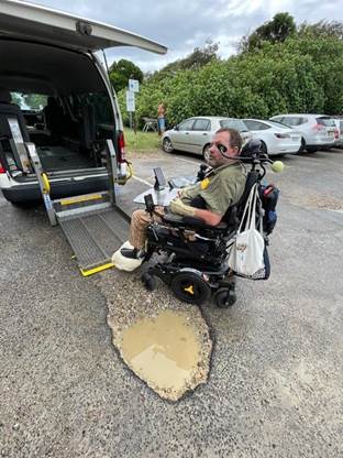 A person in a wheelchair next to a pothole

Description automatically generated