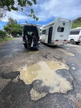 A van parked in a road with a puddle of water

Description automatically generated